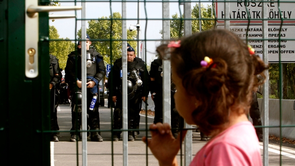 Hungarian police block a street towards the closed border crossing between Serbia and Hungary in Roszke