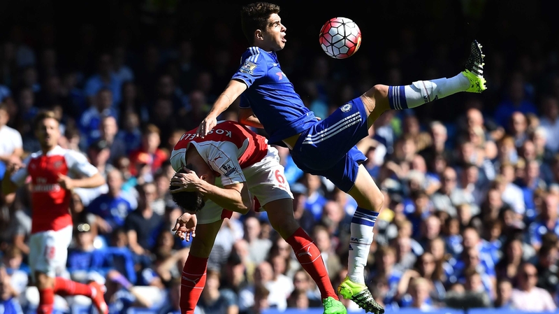 Laurent Koscielny (L) and Oscar compete for the ball