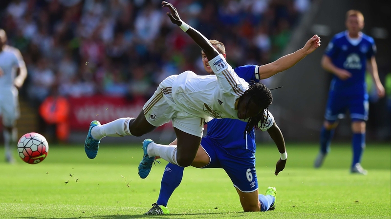 Bafetimbi Gomis of Swansea takes a fall under the challenge of Phil Jagielka