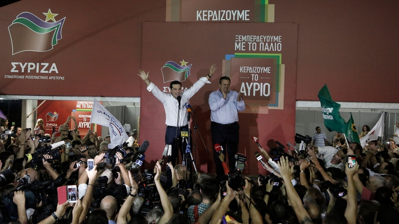 Syriza leader Alexis Tsipars (L) and leader of Independent Greeks 'ANEL' Panos Kammenos (R), wave to supporters