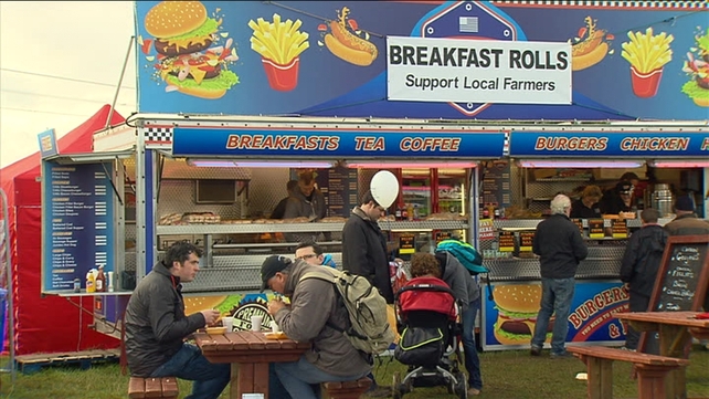 People enjoy breakfast at one of the many food stands