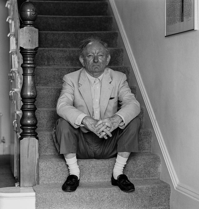 Friel sits on the stairs in his home