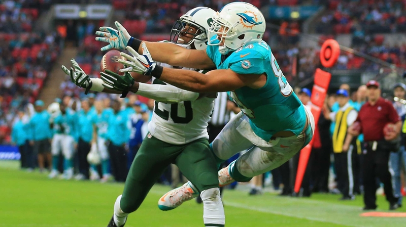 Marcus Williams (left) of the New York Jets intercepts a pass intended for Jordan Cameron of the Miami Dolphins