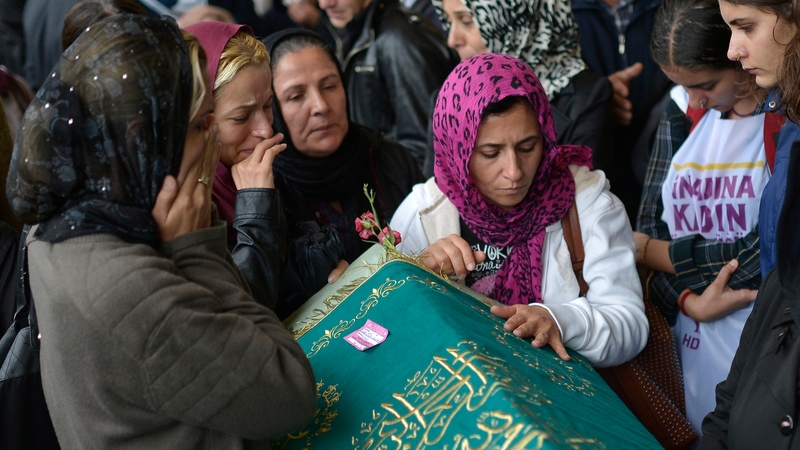 People mourn near by the coffin of one of the victims of the blast