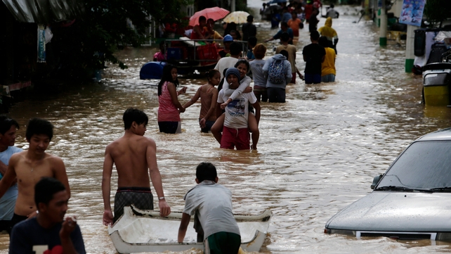Victims wade through flood water in Cabanatuan city, northern Manila