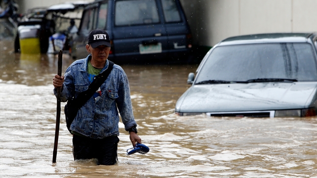 A man wades through a flooded street in Cabanatuan city, northern Manila