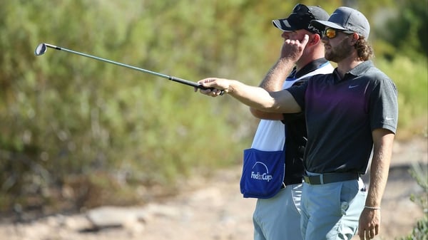 Patrick Rodgers lines up a shot with his caddie on the 15th