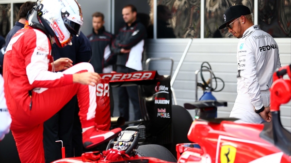 Lewis Hamilton checks out Sebastian Vettel's Ferrari's car as he climbs out in Sochi, Russia
