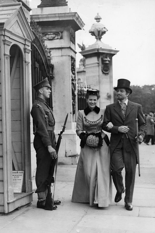 Walking past Buckingham Palace with co-star Dana Andrews while filming Britannia Mews in September 1948