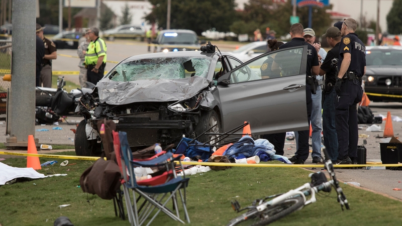 Emergency officials stand over the car involved