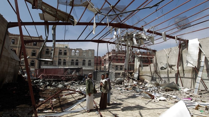 Yemeni men stand amid the rubble of a food storage warehouse following air strikes in the capital Sanaa