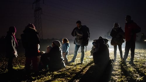 Migrants and refugees rest as they wait to board buses to go to a refugee center after crossing Croatian-Slovenian border in Rigonce