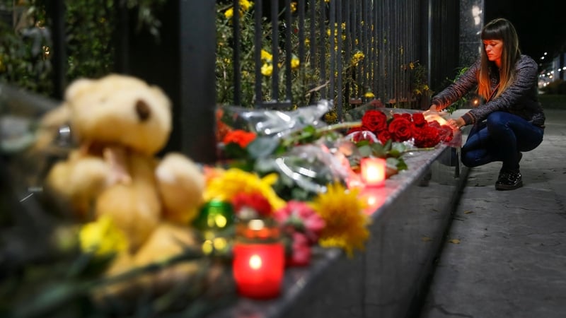 A woman lays flowers at the Russian embassy in Kiev after the crash, which killed 224 people, including some Ukrainians
