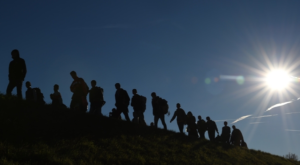 A group of people cross from Austria into Germany