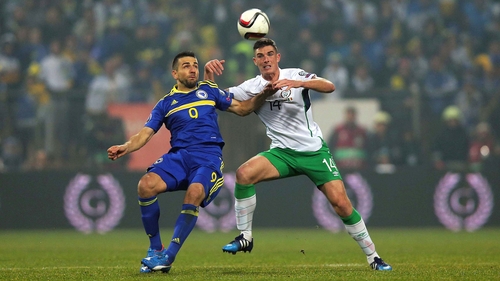 Ciaran Clark challenges Vedad Ibisevic in the 1-1 draw in Zenica