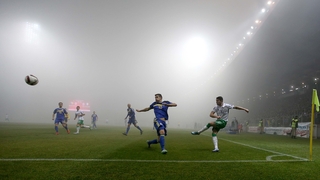 Ireland's Robbie Brady clears as a thick fog covers the pitch