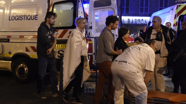 Rescue workers evacuate injured people near the Bataclan concert hall