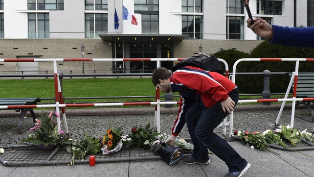 A man lays flowers outside the French Embassy in Berlin a day after the deadly attacks in Paris