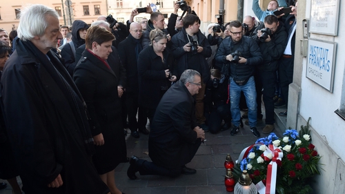 Polish Prime Minister designated Beata Szydlo (2L) places flowers in front of the French consulate