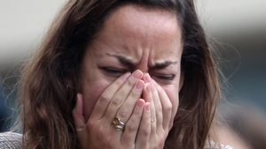 A woman breaks down outside Le Carillon bar in Paris