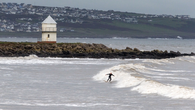 A surfer takes advantage of waves produced by rough seas in Porthcawl, Wales