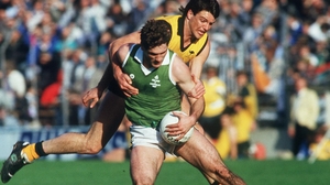 Dermot McNicholl of Ireland and Paul Roos of Australia in action