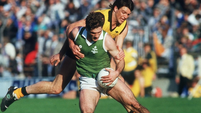 Dermot McNicholl of Ireland and Paul Roos of Australia in action