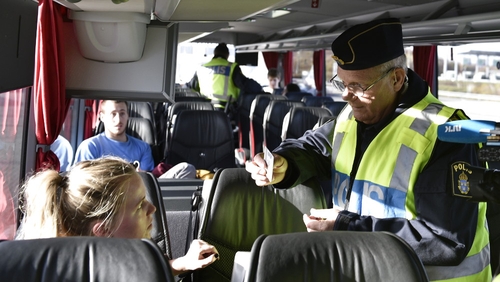 A police officer checks the papers of a train passenger travelling from Denmark at Lernacken on the Swedish side of the Oresund strait