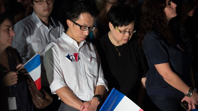 Mourners take park in a minute of silence during a vigil at Tamar Park in Hong Kong, China