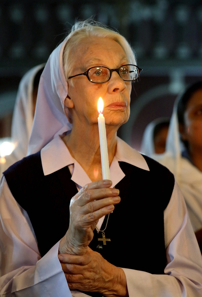 A member of the Pakistani Christian minority holds a candle during a vigil in Lahore, Pakistan