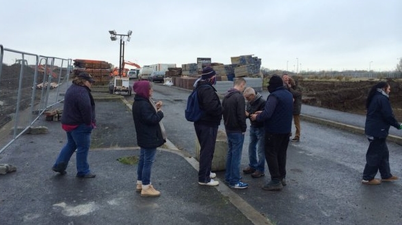 Around 20 people have gathered at the entrance of the site on Balbutcher Lane in Ballymun