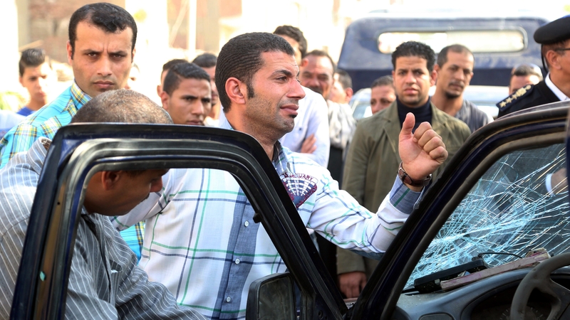 Egyptian police officers react to the death of their colleagues at the site of the attack near Cairo
