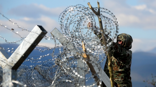 A Macedonian army soldier finishes the razor-wired fence along the border with Greece