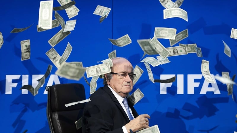 Sepp Blatter looks on as fake dollar notes fly around him, thrown by a British comedian during a press conference at the FIFA headquarters in July