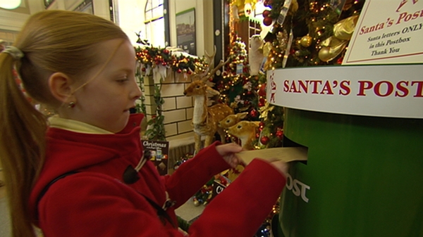 A young girl posts her letter to Santa Claus