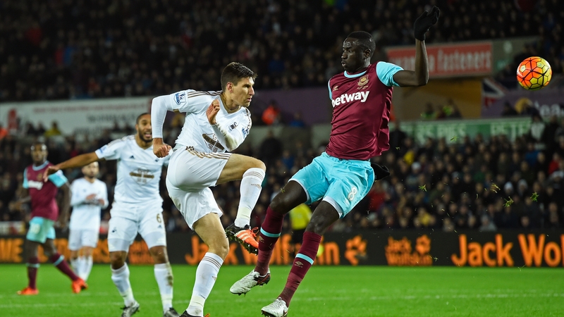 Federico Fernandez of Swansea City shoots under pressure from Cheikou Kouyate of West Ham