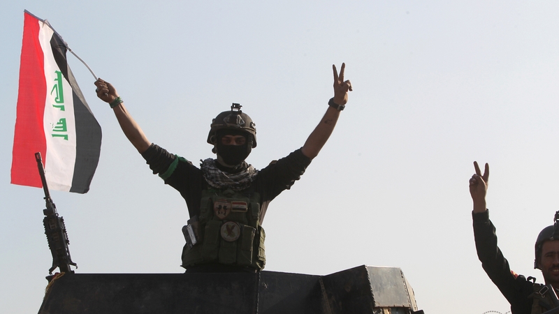 Soldiers wave the Iraqi flag at the central complex in Ramadi