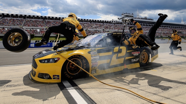 Brad Keselowski crashes into his crew on pit road during the NASCAR Sprint Cup Series at Pocono Raceway