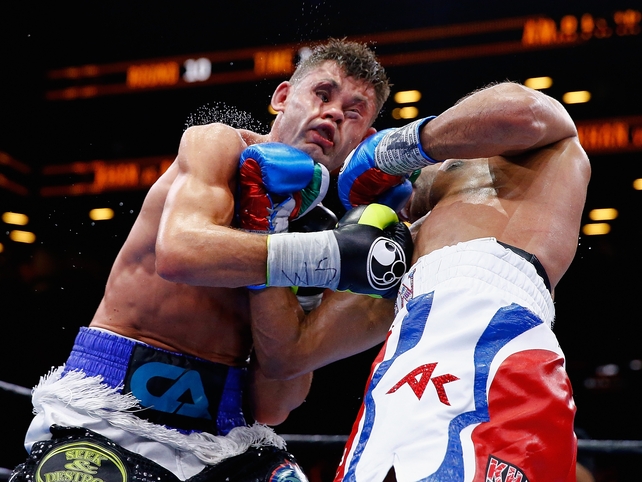 Amir Khan (R) punches Chris Algieri during their Welterweight bout in Brooklyn