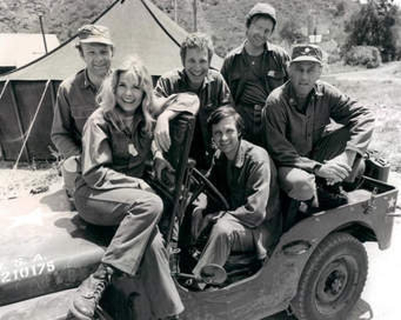 Wayne Rogers (centre, back) surrounded by other M*A*S*H stars (clockwise) Loretta Swit, Larry Linville, Gary Burghoff, McLean Stevenson, and Alan Alda