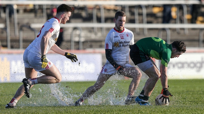 Ryan Murray Murray of Queen's stoops to pick the ball off a wet pitch against Tyrone