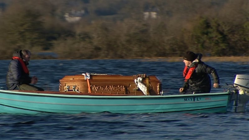 A boat brings the remains to Saints' Island Cemetery in Co Longford