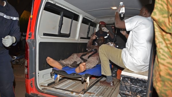 A wounded man is treated outside the hotel in Ouagadougou