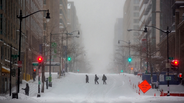 Three people attempt to cross 12th Street during a major blizzard in Washington