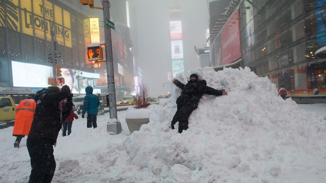 A man lies in a pile of snow in Times Square, New York
