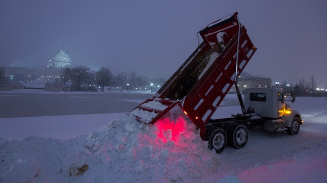 A truck dumps plowed snow from the streets outside the US Capitol in Washington
