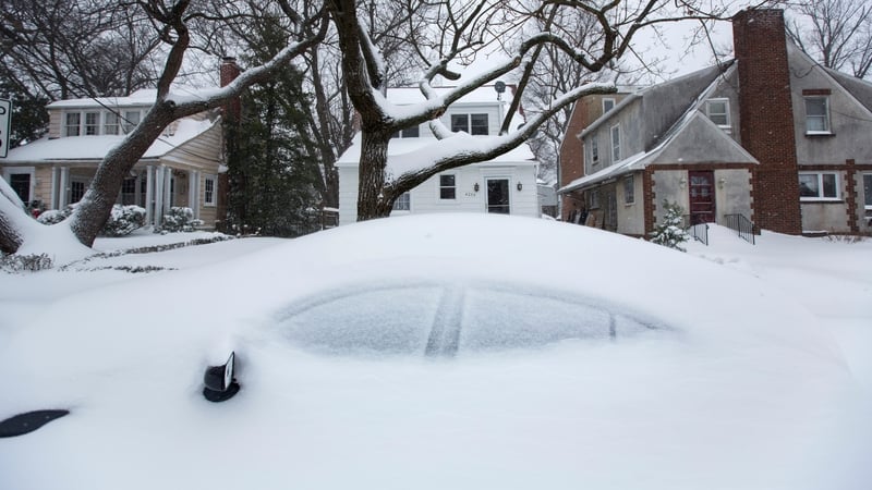 Snow accumulates on a parked car in Washington