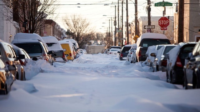 Cars sit parked on an unplowed street in Philadelphia, Pennsylvania