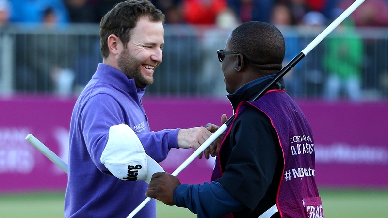 Grace celebrates victory on the 18th with his caddie Zack Rasego