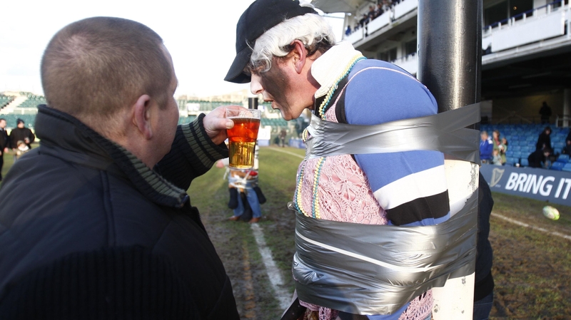A rugby fan takes a drink during a club game in England
